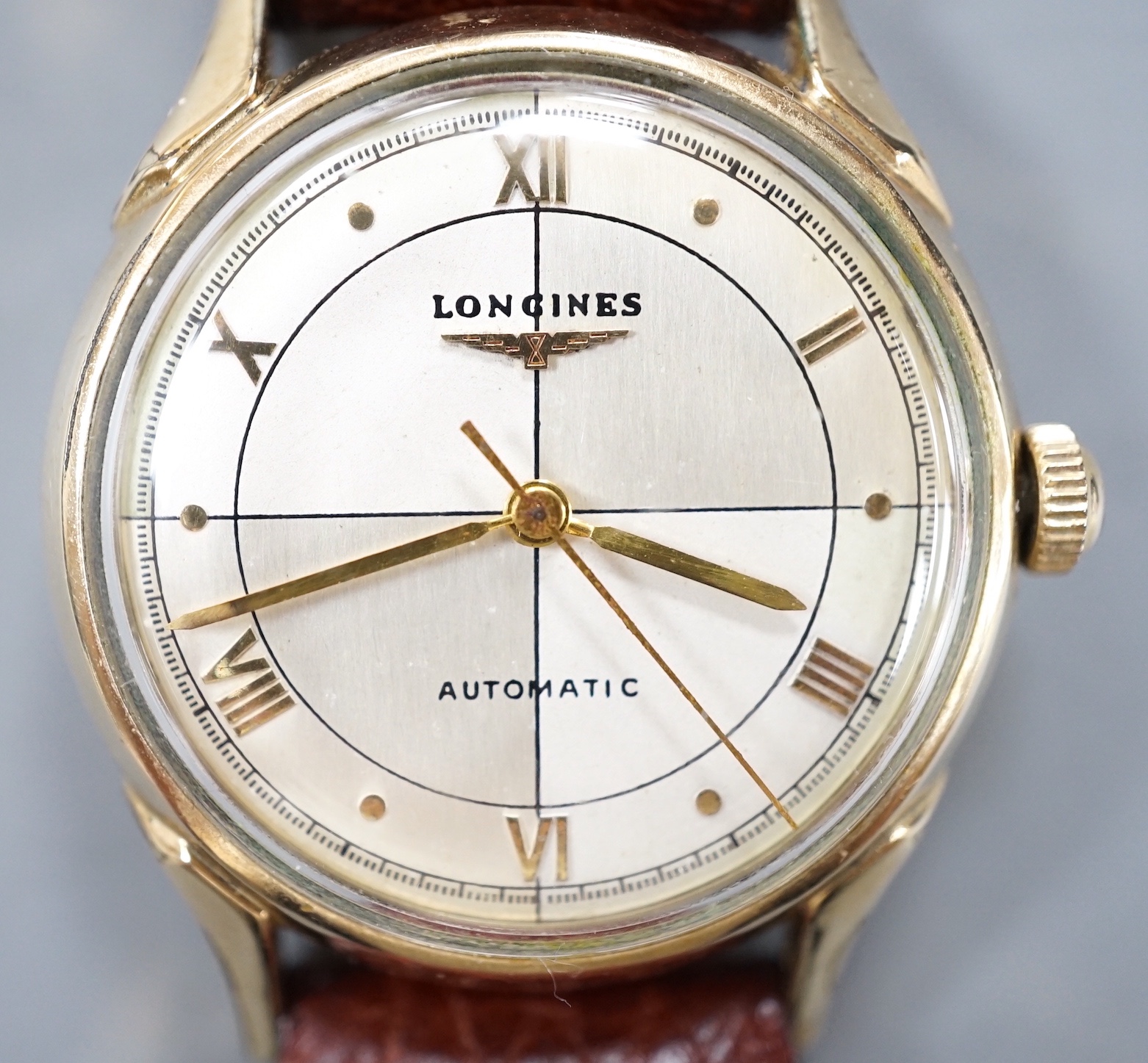 A gentleman's 10k gold filled Longines automatic wrist watch, the 'quartered' dial with Roman and dot markers, on a brown leather strap, case diameter 33mm.